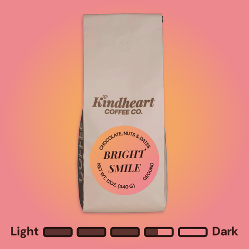 Kindheart Coffee Co. Bright Smile Blend Ground coffee bag on an pink and orange background with Medium Dark Roast bubbles 3.5 out of 5 roast level.