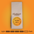 Kindheart Coffee Co. Warm Hug Blend Whole Bean coffee bag on an orange background with Medium Dark Roast bubbles 4 out of 5 roast level.